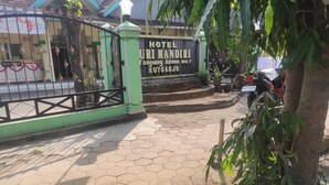 A gated entrance to Hotel Uri Mandiri, featuring a sign with the hotel's name and address. - OYO 93048 Hotel Puri Mandiri (Kutoarjo)