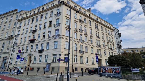 A multi-story building with a classic architectural style, featuring numerous windows and balconies. - Luxury Living Kopernik (Warszawa)