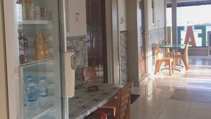 A hotel lobby with a refrigerator stocked with beverages, a tiled floor, and a dining area with chairs and a table. - OYO Life 93055 Fathin Hotel (Sangkapura)