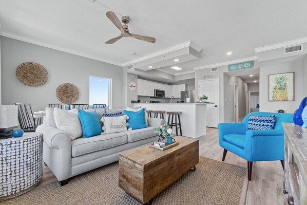 A modern living room with a grey sofa, blue armchairs, and a wooden coffee table.