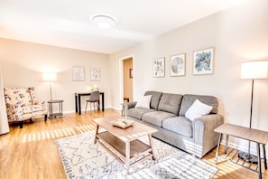 A living room with a sofa, a coffee table, a patterned rug, a chair, and a lamp.