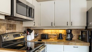 A modern kitchen with stainless steel appliances, a microwave, a coffee maker, and a toaster. - Village Loft 31 At Park City Mountain 2 Bedroom Condo by RedAwning (Park City)