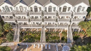 A multi-story hotel with a swimming pool, outdoor seating, and a well-maintained garden. - ☀️Short Walk to Beach-Pet Friendly-4 Bikes-Bluebonnet by the Beach☀️ (Santa Rosa Beach)