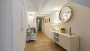 A hallway with a white console table, a round mirror, and a shelf with decorative items. - Madame Betta by Mmega (Florence)