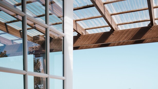 Un balcon donnant sur une piscine et une végétation luxuriante.