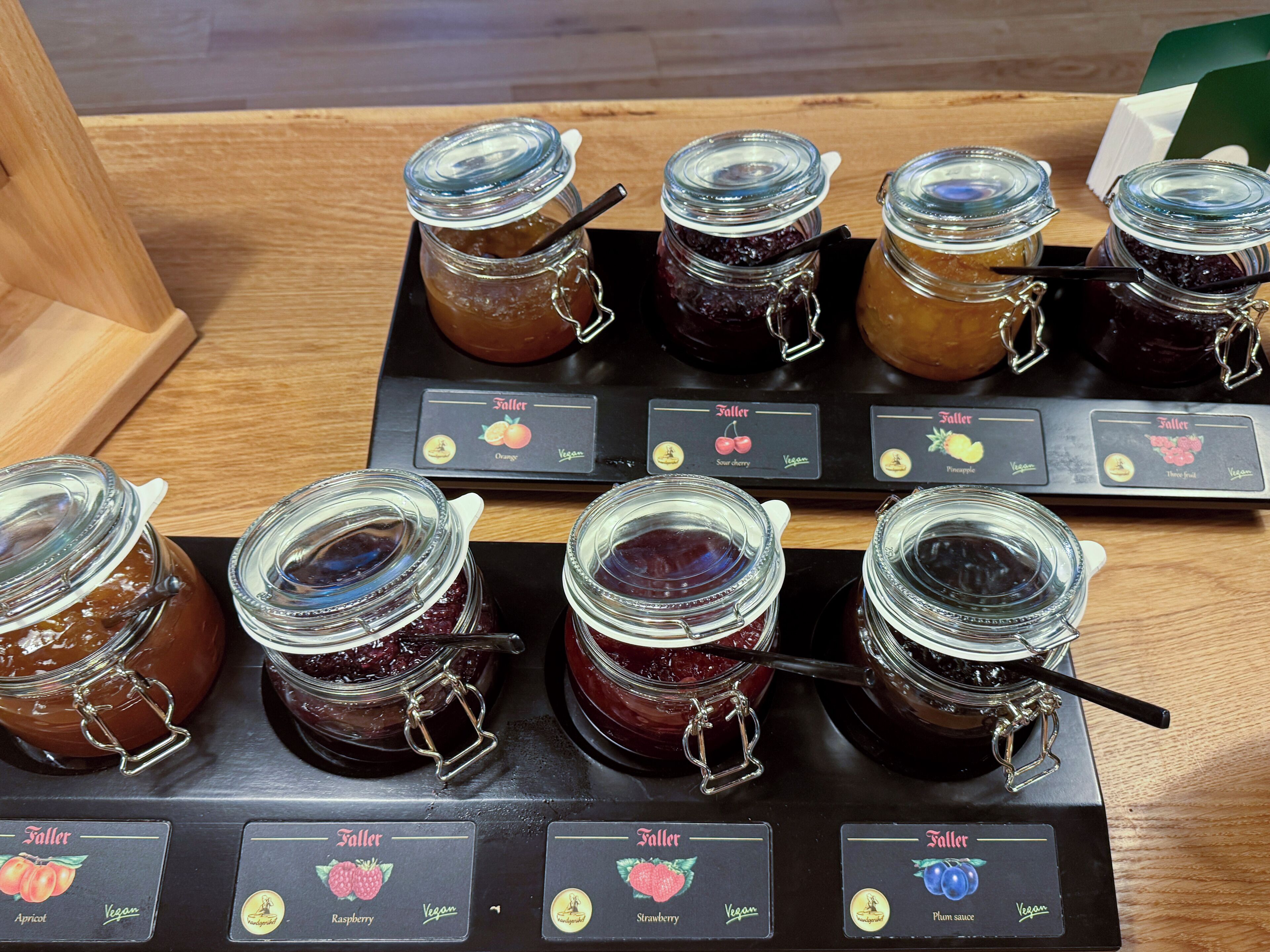 Exhibición de botes con mermeladas de diferentes sabores, como albaricoque, frambuesa y salsa de ciruela.