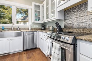 Enjoy cooking in this well-equipped kitchen with a window offering a view of the outdoors.