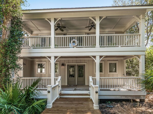 Enjoy the serene surroundings and expansive balcony with ceiling fans and decorative railing.
