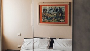 Une chambre à coucher avec un lit, un tableau encadré au mur et un plafond en bois.