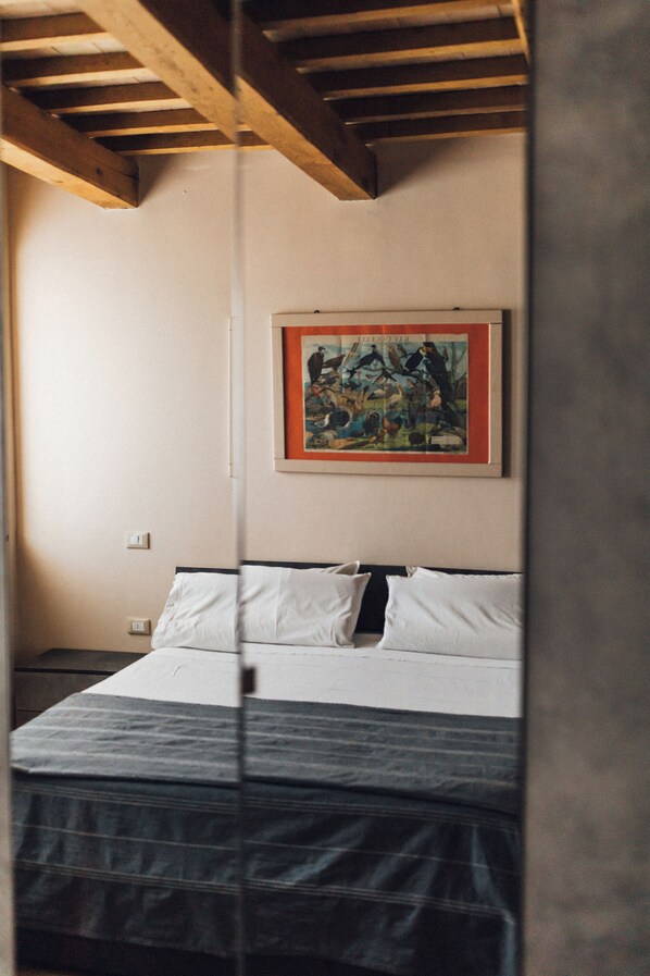 A bedroom with a bed, a framed picture on the wall, and a wooden ceiling. - Podere Biricocolo-Il Cortile- In the  countryside, 20 km from  Siena.  (Toscana)