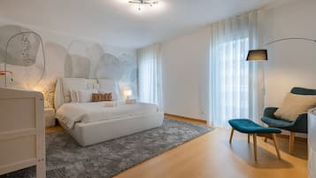 Quarto moderno com uma cama grande, uma escrivaninha, uma cadeira e uma luminária.