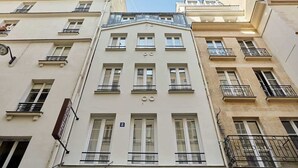 Ein mehrgeschossiges Gebäude im klassischen Stil, mit symmetrisch angeordneten Fenstern und Balkonen.