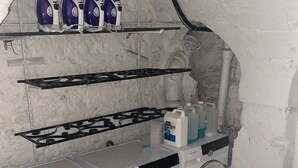 Un espace buanderie compact comprenant un lave-linge, un sèche-linge et une planche à repasser.