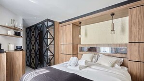 Een moderne slaapkamer met een groot bed, een houten hoofdbord en inbouwplanken.