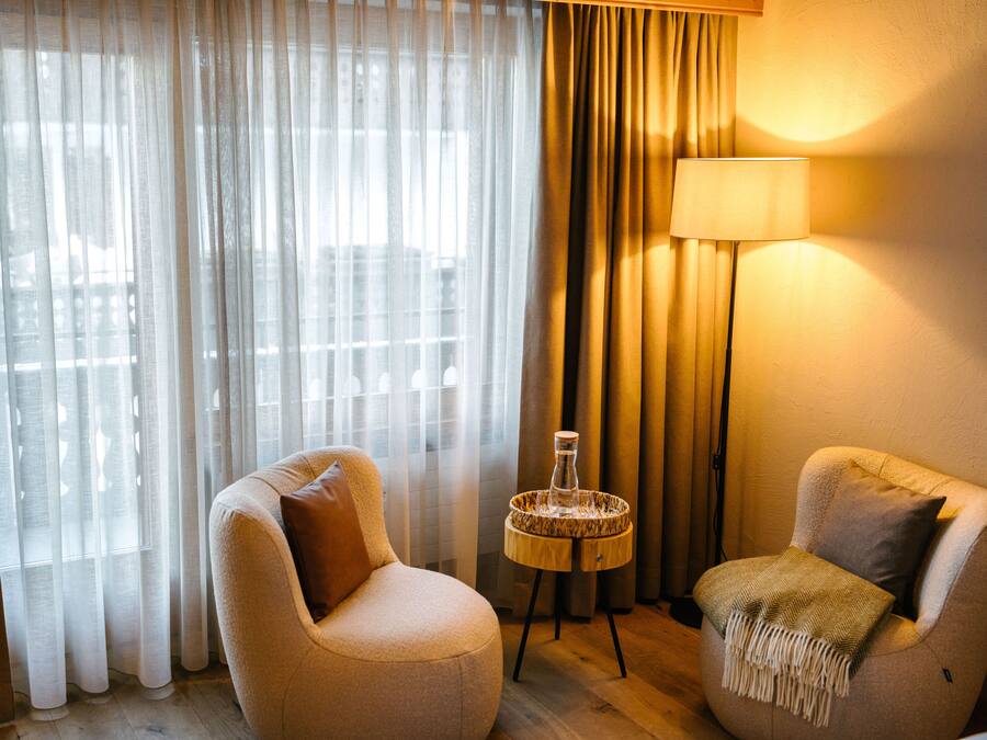 A room with two armchairs, a lamp, and a small table with a decorative item.