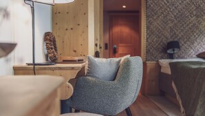 A cozy room with a wooden desk, a chair, and a bed. - Seven Alpina Boutique Hotel (Klosters-Serneus)