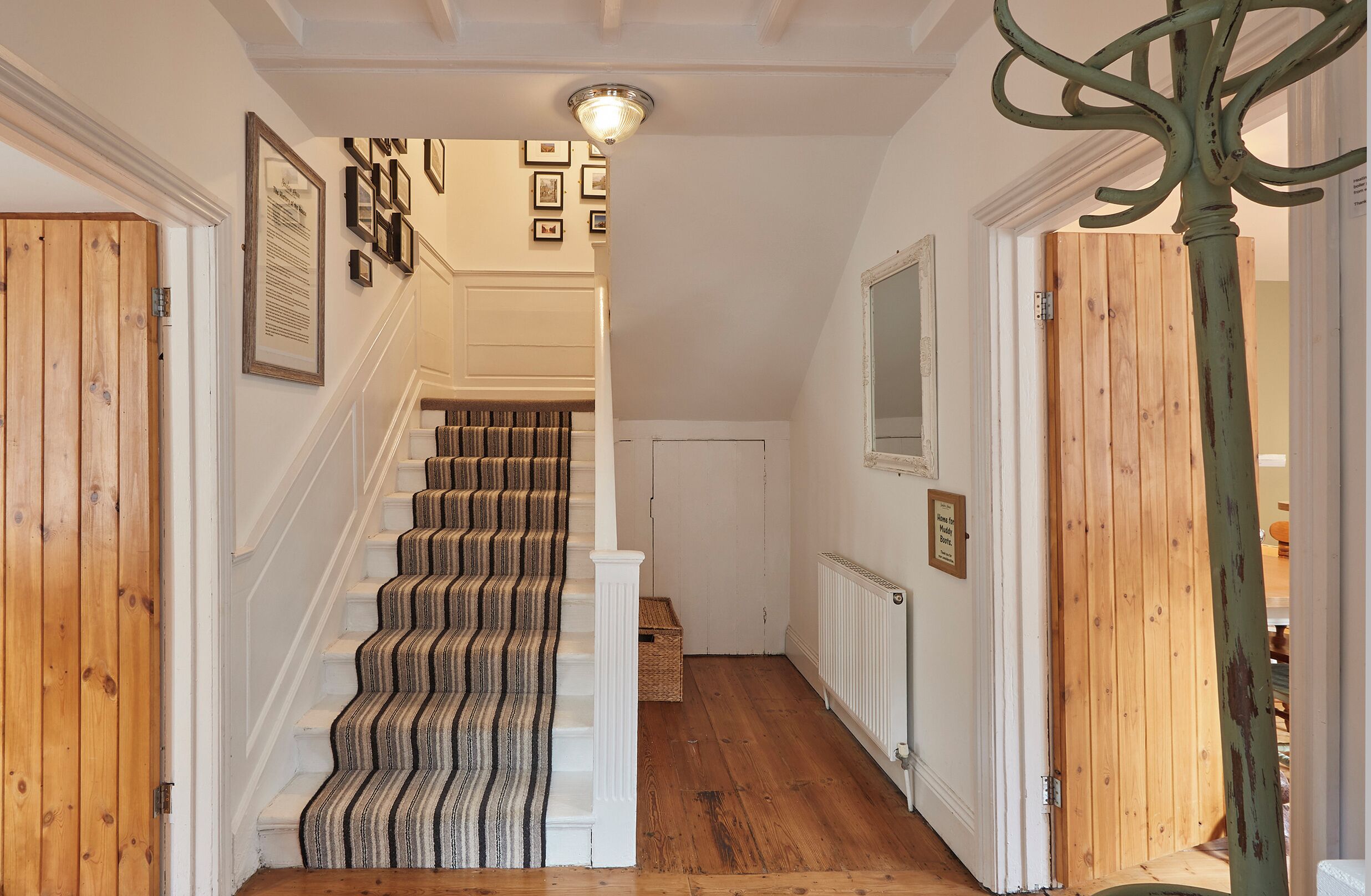 A staircase with a patterned carpet, white walls, and wooden doors.
