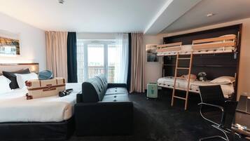 Une chambre d’hôtel comprenant un lit, un canapé, un lit superposé, un bureau et une chaise.