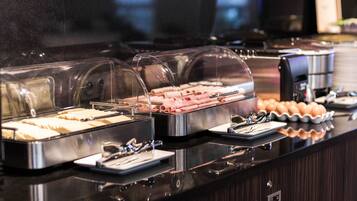 Een buffet met diverse gerechten onder glazen deksels.