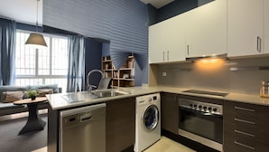 A modern kitchen with a dishwasher, washing machine, and oven. - Cosy studio close to city center in Sants (L'Hospitalet de Llobregat)