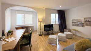 A modern apartment with a dining area, a living room, and a TV. - Comfortable 3-bedroom apartment with terrace, close to the center (L'Hospitalet de Llobregat)