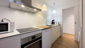 Eine kleine Küche mit Mikrowelle, Herd, Backofen und Kaffeemaschine.