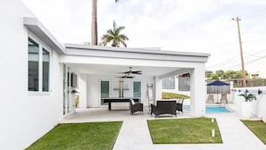 A modern house with a covered patio, a pool, and a well-maintained lawn. - Luxury Casa CALIAD (San Juan)