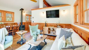 A cozy living room with a fireplace, wooden furniture, and a television mounted on the wall. - Secluded Livingston Retreat w/ Deck + Fire Pit! (Livingston)