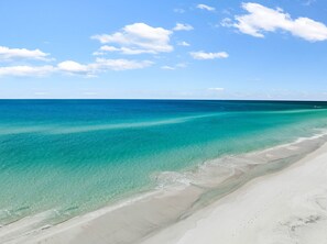 Ein Strand mit klarem türkisblauem Wasser und einem Sandstrand.