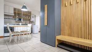 Una cocina moderna con comedor, que incluye una mesa, sillas, microondas y un banco empotrado.