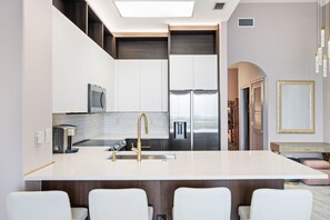 Una cocina moderna con una isla central, electrodomésticos de acero inoxidable y un diseño minimalista.