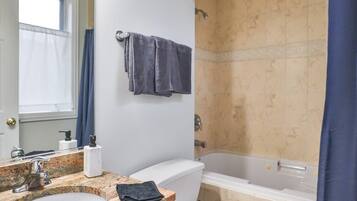 Bathtub, hair dryer, towels, shampoo