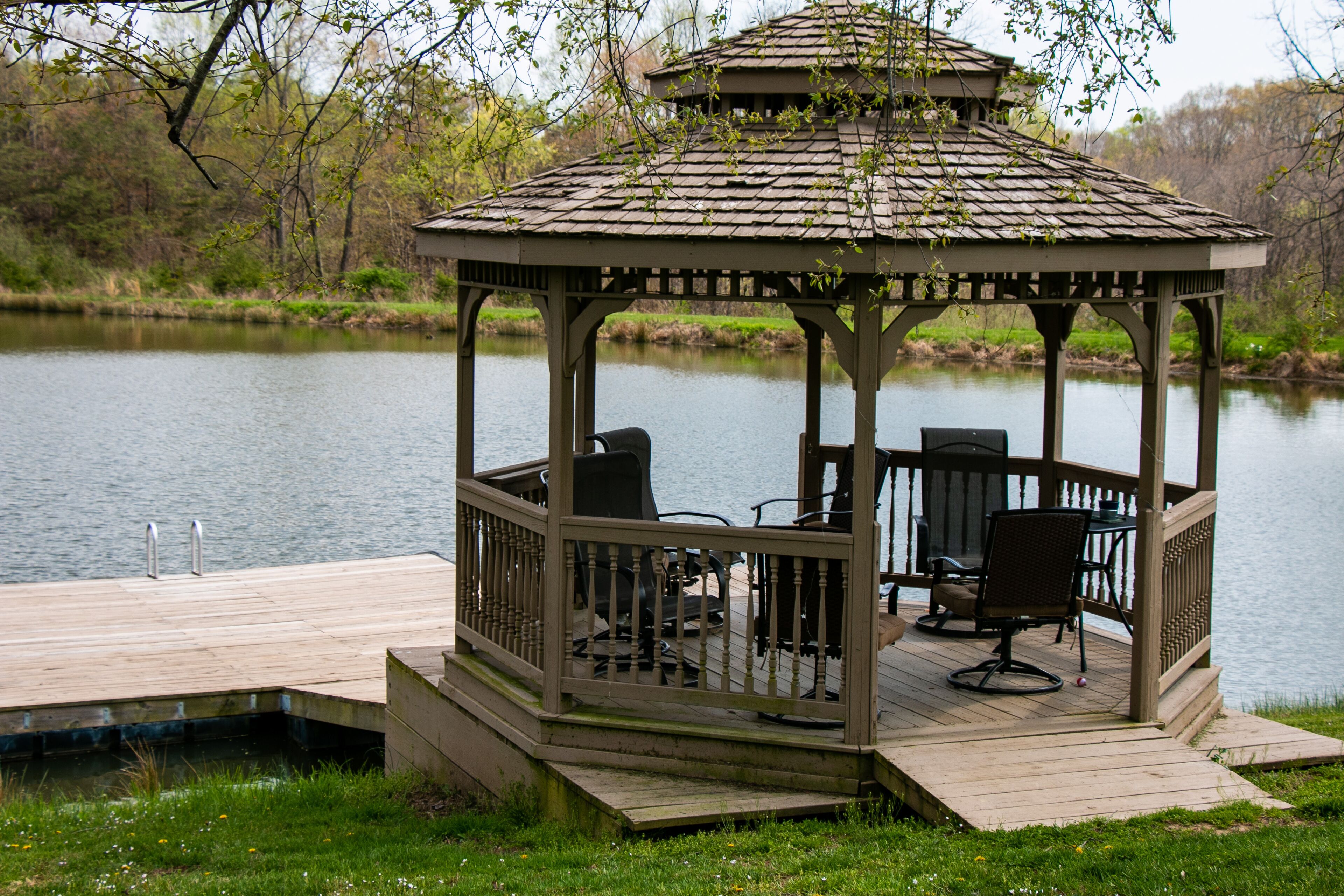 Un belvédère doté d’une terrasse en bois et d’un espace salon offrant une vue sur un lac.
