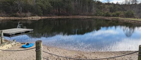 A calm lake with a dock and a rope barrier.