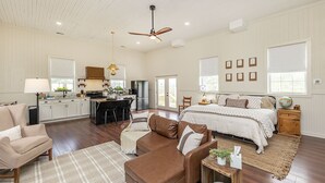 A spacious living area with a large bed, a dining area, and a kitchen. - The Little Red Schoolhouse (Cross Junction)