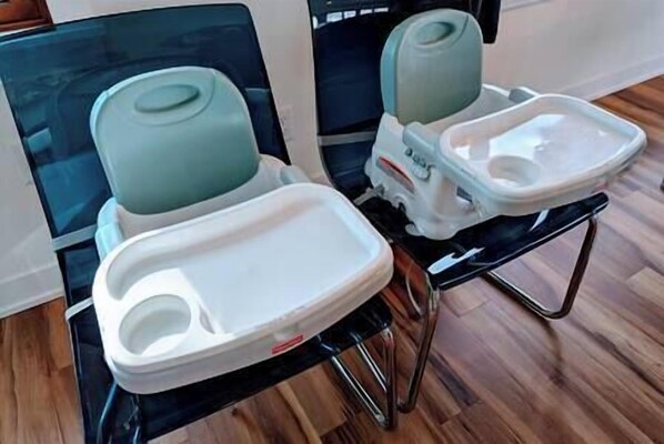 Two portable toilets with lids and footrests, placed on a wooden floor.