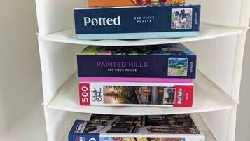 Ein Bücherregal mit drei Puzzlespielen.