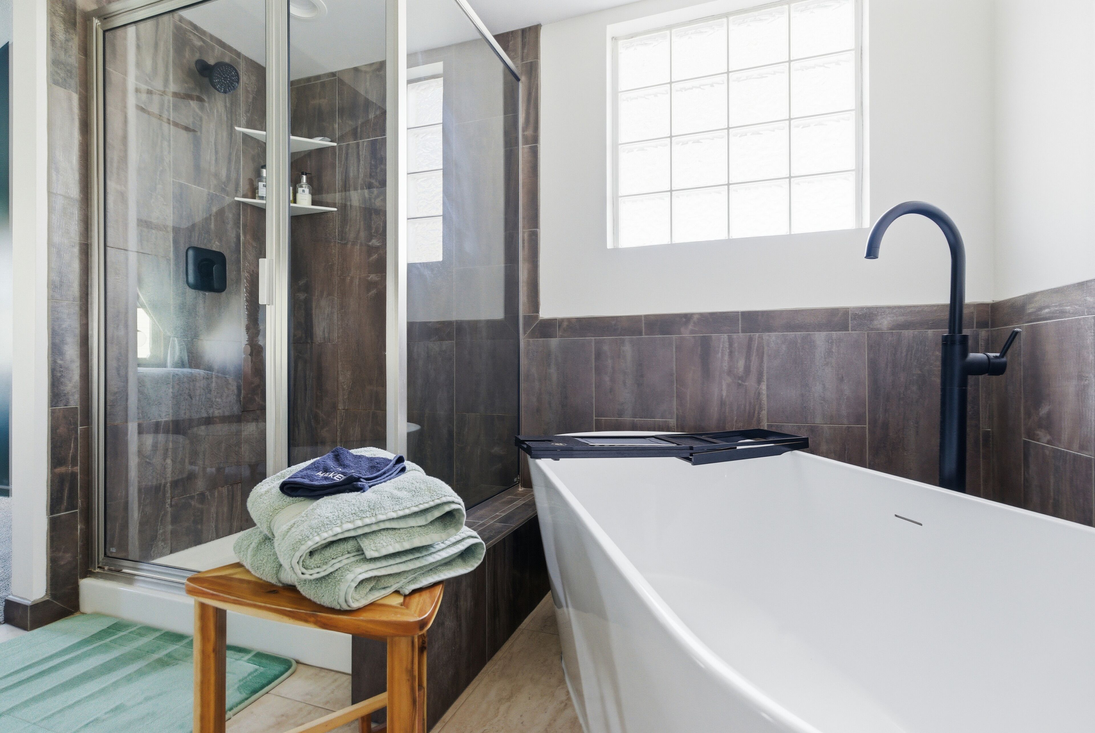 Une salle de bain moderne avec une baignoire, une douche et une fenêtre.