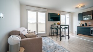 A modern apartment with a living room, a dining area, and a kitchen. - Carré d’As - Appartement de standing (Le Bourget)