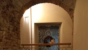 A narrow corridor with a stone wall on one side and a balcony with a metal railing. - Clery house, a stone's throw from Florence, Tuscan style (Montelupo Fiorentino)