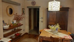 A dining area with a wooden table, chairs, a decorative lamp, and a vase with flowers. - Clery house, a stone's throw from Florence, Tuscan style (Montelupo Fiorentino)