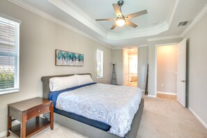 A bedroom with a bed, nightstand, ceiling fan, and artwork on the wall. - Punta Gorda Home w/ Lanai & Golf Course View! (Punta Gorda)