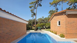 A rectangular swimming pool with clear blue water, surrounded by a brick wall and a small brick building with a window. - Moradia Privada COM Piscina Perto DA Praia (Apúlia)
