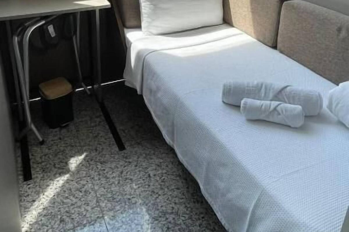 Una habitación de hotel pequeña con cama, un escritorio y una silla.