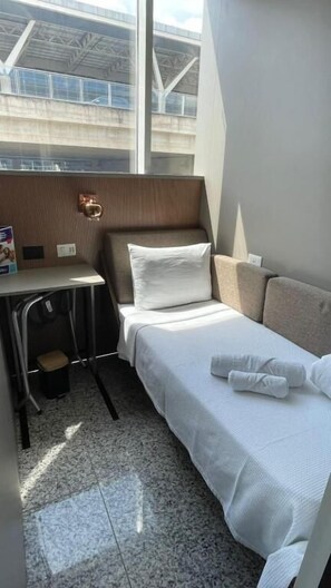 A compact hotel room with a bed, a small desk, and a chair. - Hotel Aero Sleep de Viracopos (Campinas)
