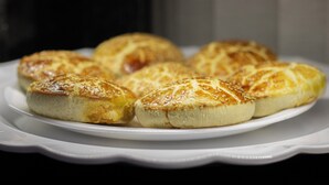 A plate of golden-brown pastries with sesame seeds on a white plate.