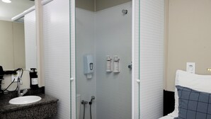 A bathroom with a shower, toilet, and sink.