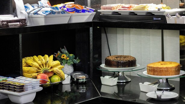 A buffet with various food items including fruits, cakes, and pastries.