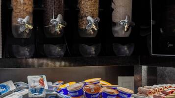 Un mostrador de autoservicio con diversas opciones de alimentos y bebidas, incluyendo botes de granola y recipientes de yogur.