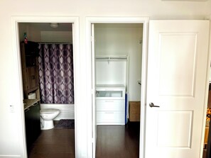 A bathroom with a toilet, a shower curtain, and a white cabinet. - Entire Corner Unit in Prime Toronto Location. Steps from Subway, Shops & Dining (Toronto)
